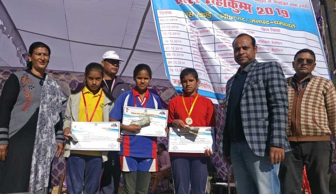 लोहाघाट खेल महाकुंभ में विजेता प्रियंका, भावना, रिया को पुरस्कृत करते बीईओ हरेंद्र साह।