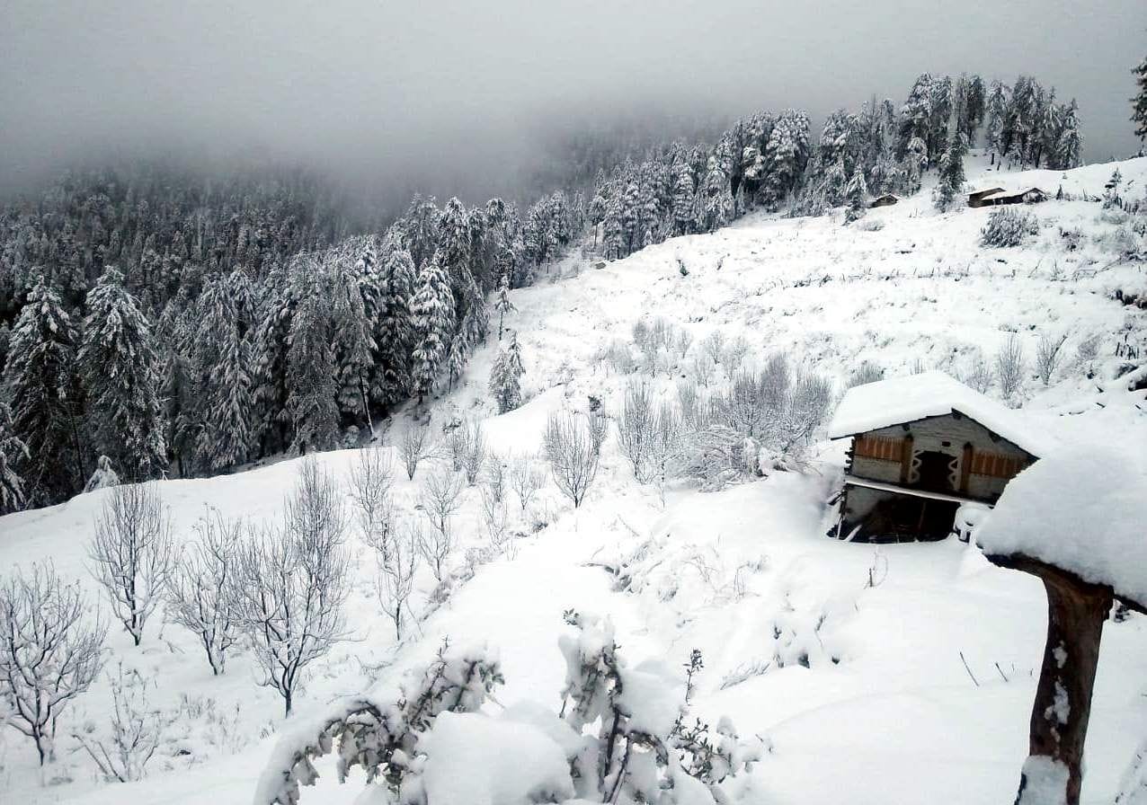 चकराता के मुंगाड़ गांव में बर्फ से ढकीं पहाड़ियां।