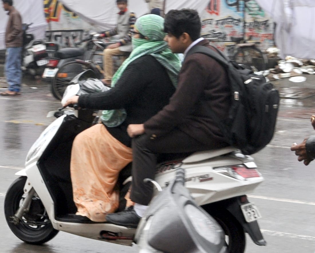 शामली कैराना रोड पर बरसात में स्कूटी पर जाती महिला व छात्र शामली कैराना रोड पर बरसात में स्कूटी पर जाती महिला व छात्र
