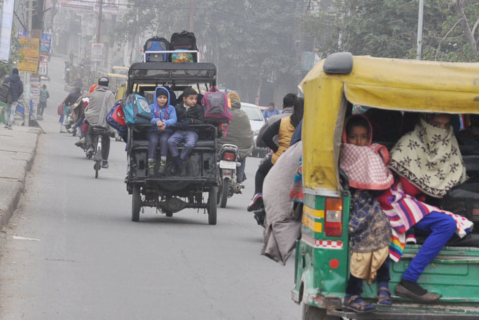 ठंड में स्कूल जाते बच्चे।