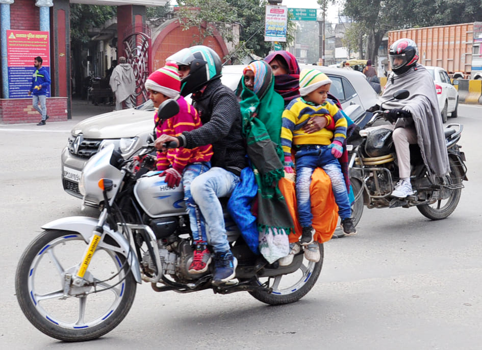 सहारनपुर में पड़ती ठंड में गर्म कपड़ों का सहारा लेते बाइक सवार लोग।