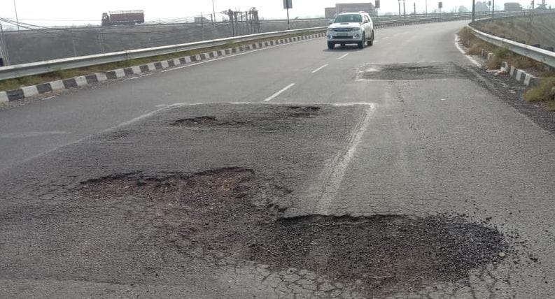 केएमपी गोलचक्र के पास टूटकर बिखरी सड़क।