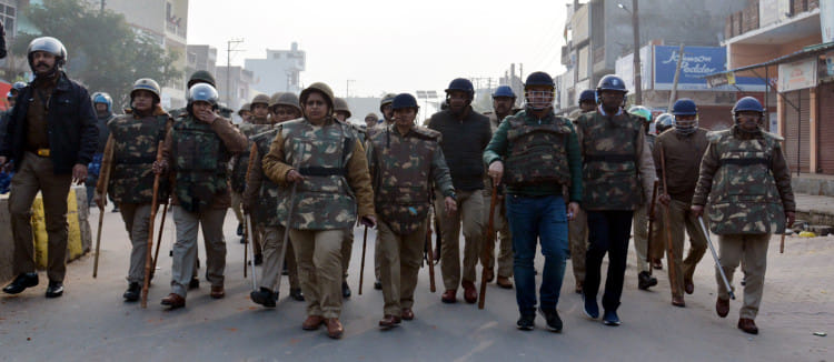 मुजफ्फरनगर में कच्ची सड़क पर पथराव के बाद मार्च करता पुलिसबल।