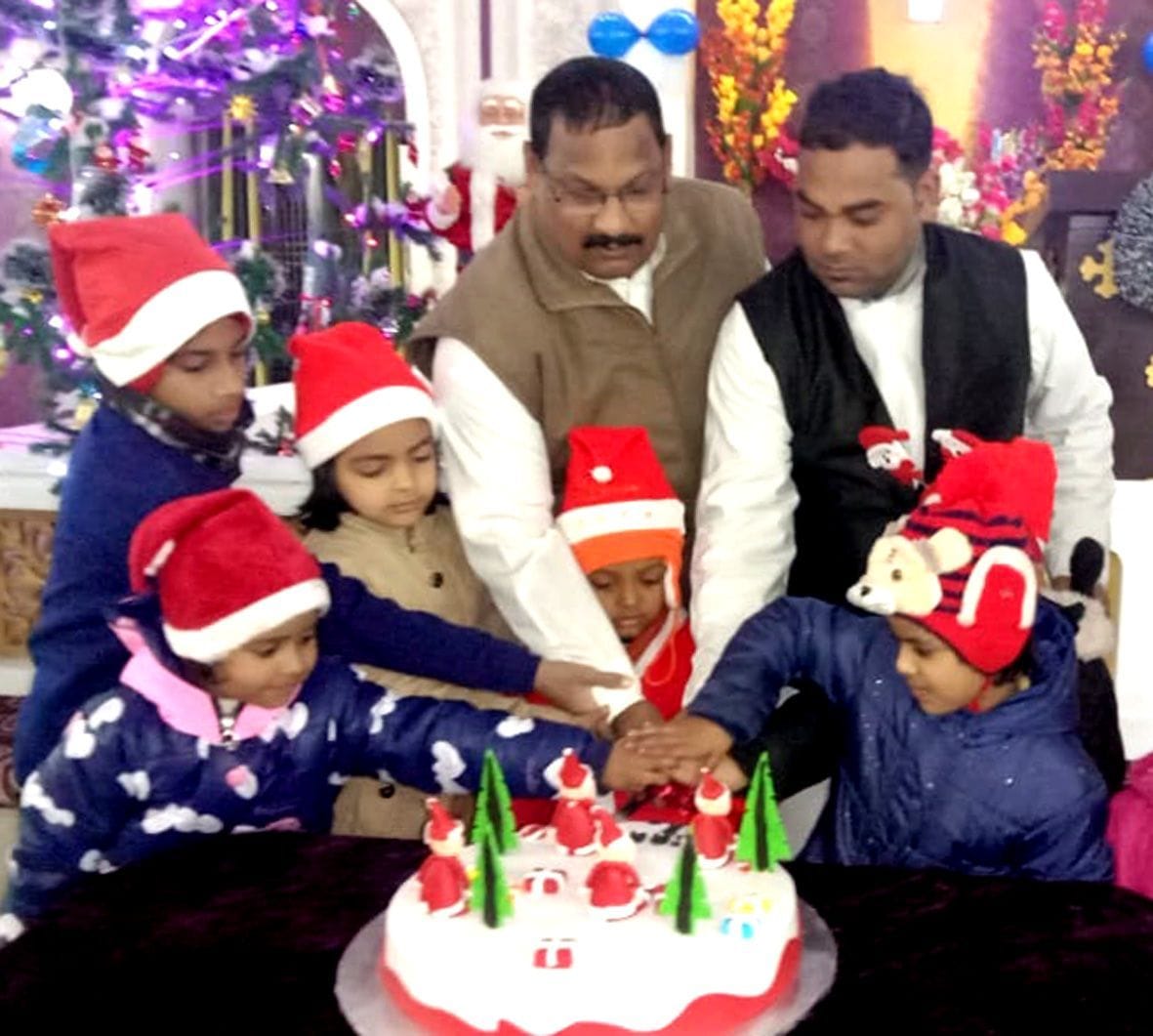 बन्ना देवी सेंट्रल मैथोडिस्ट चर्च में क्रिसमस डे पर बच्चों के साथ केक काटते फादर यूसुफ दास, फादर ? बन्ना देवी सेंट्रल मैथोडिस्ट चर्च में क्रिसमस डे पर बच्चों के साथ केक काटते फादर यूसुफ दास, फादर ?