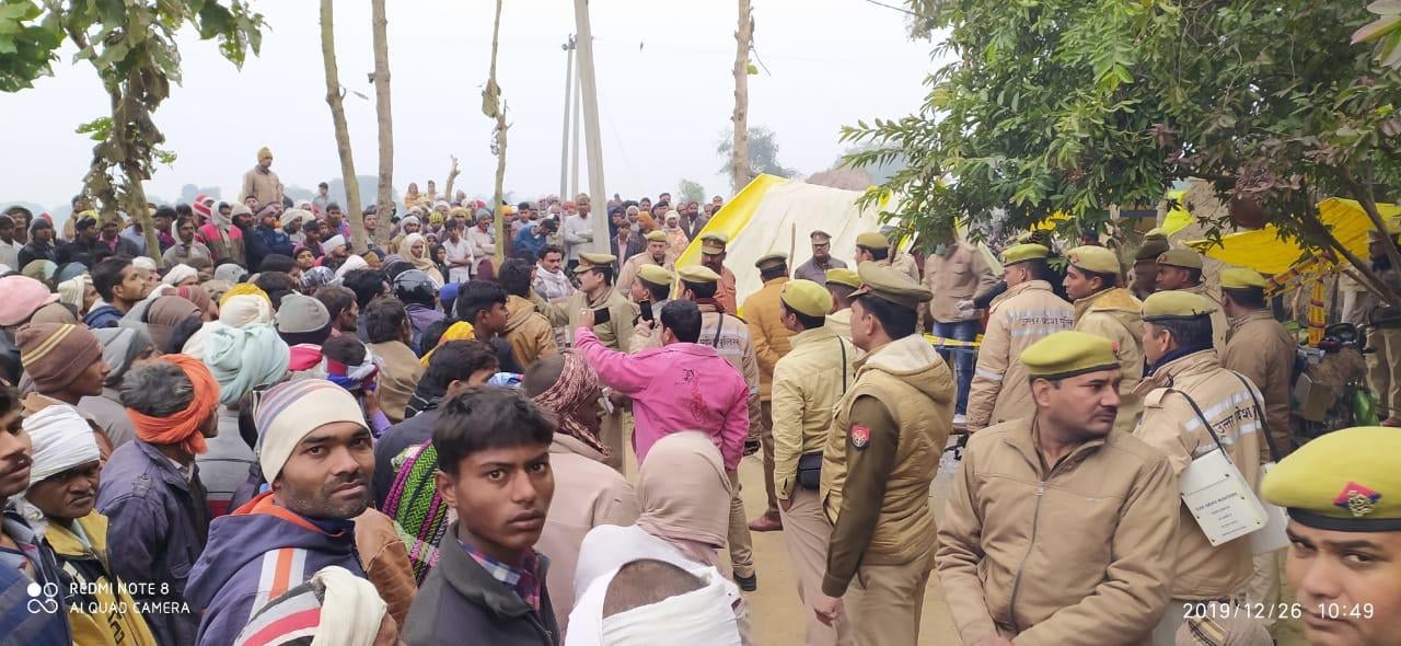 घटनास्थल पर भीड़ को रोकती पुलिस।
