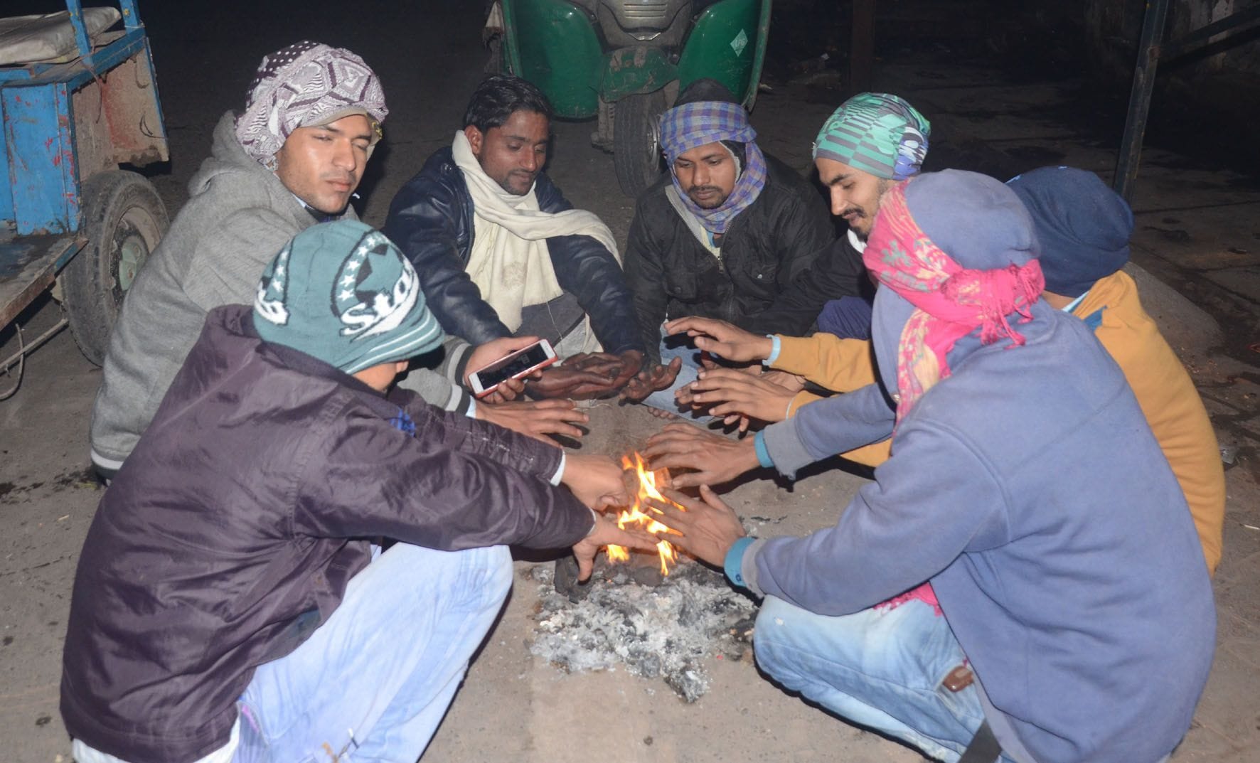 माल गोदाम पर लकड़ी जलाकर ठंड से राहत पाते मजदूर लोग।