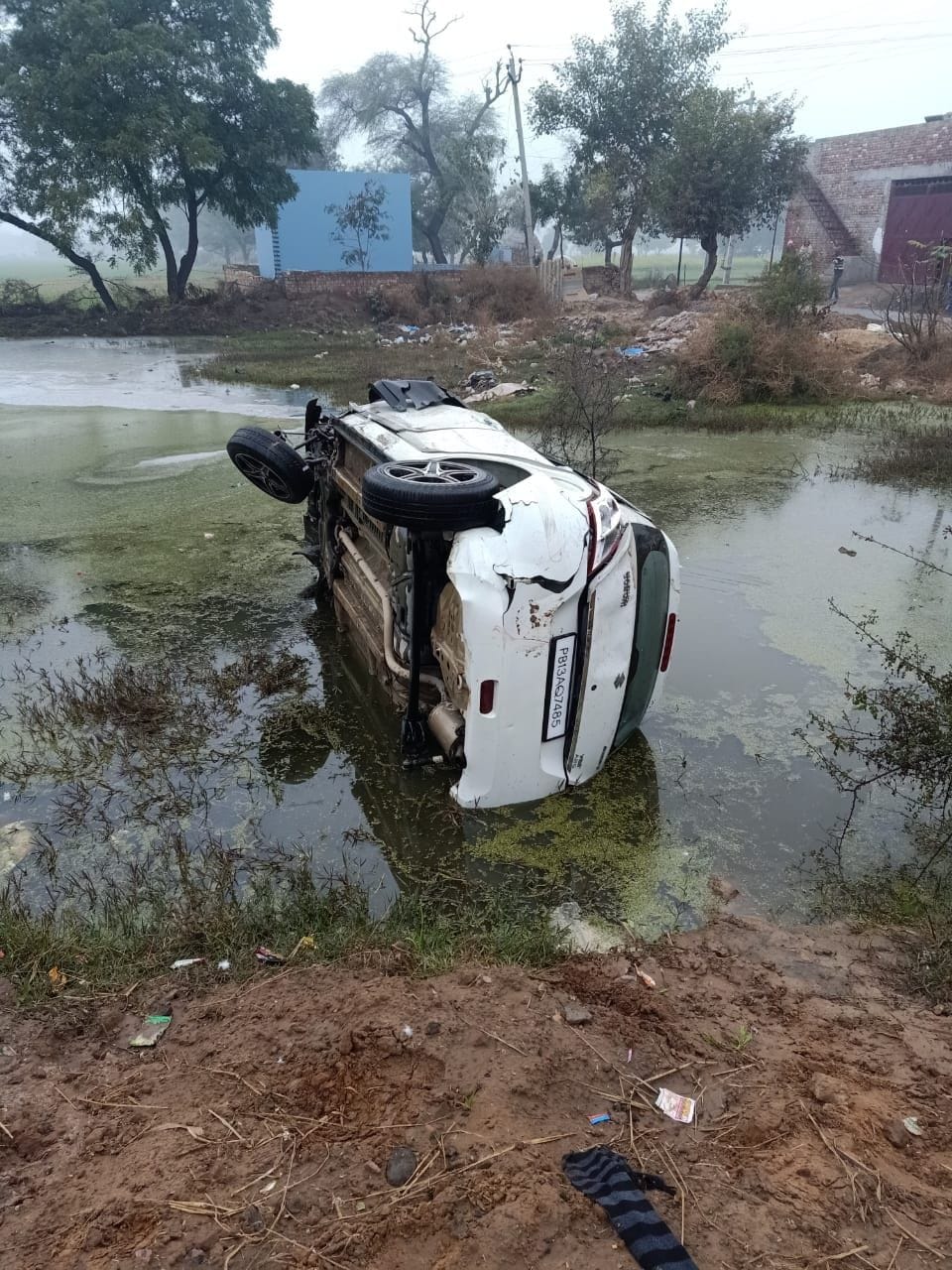 अलाव ताप रहे छह लोगों को रौंदने के बाद सड़क किनारे पानी में पलटी कार। अलाव ताप रहे छह लोगों को रौंदने के बाद सड़क किनारे पानी में पलटी कार।