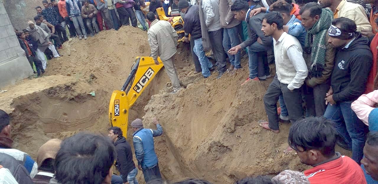 नहटौर के गांव सदरूदीनगर में कुएं की मिट्टी की ढांग गिरने से दबे मजदूर को निकालती जेसीबी।