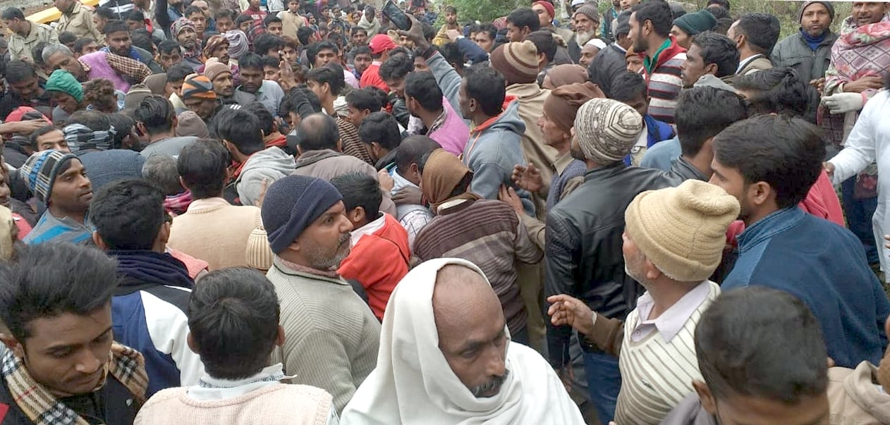 नहटौर के गांव सदरूदीनगर में कुएं की मिट्टी की ढांग गिरने से हुई मजदूर की मौत के बाद जमा भीड़।