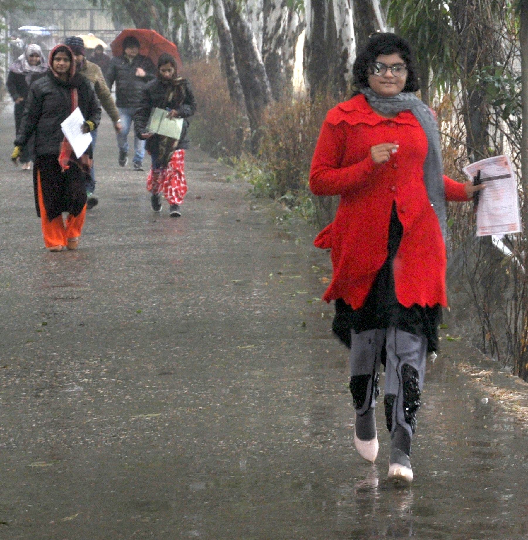 शामली के वीवी डिग्री कॉलेज में बरसात के दौरान दौड़ लगाकर टीईटी देने के लिए जाती महिला अभ्यर्थी। शामली के वीवी डिग्री कॉलेज में बरसात के दौरान दौड़ लगाकर टीईटी देने के लिए जाती महिला अभ्यर्थी।