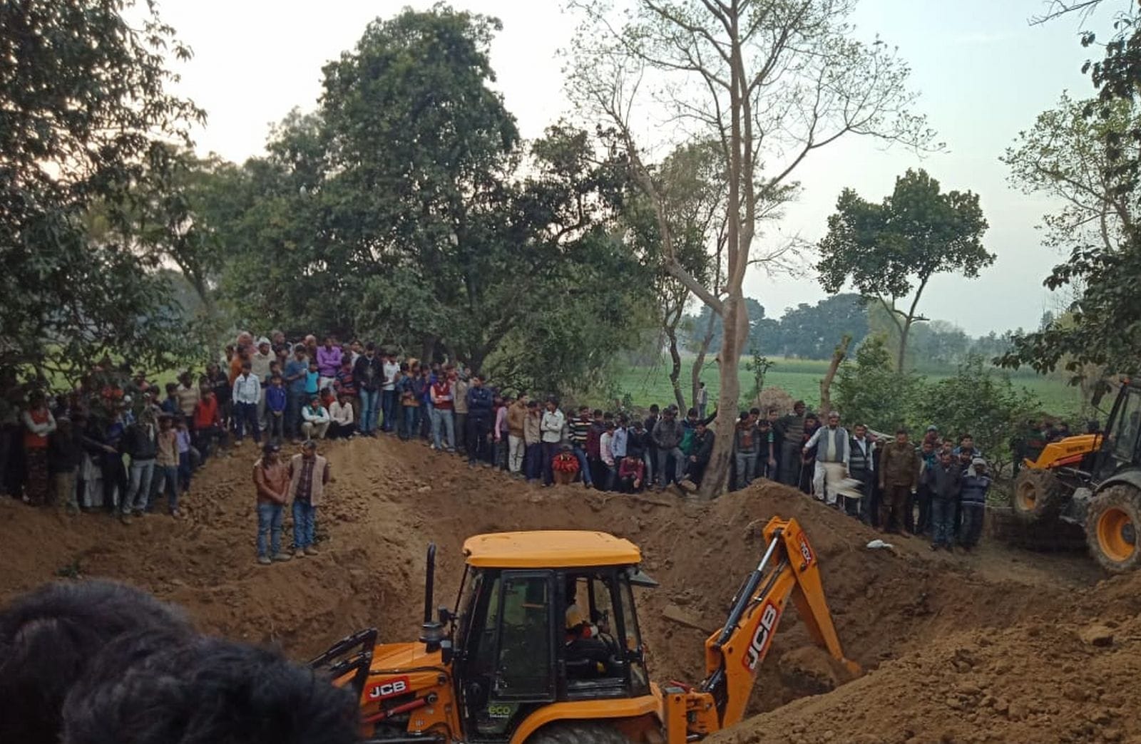 इस्लामनगर में मिट्टी की ढांग में दबे युवक को निकालने का प्रयास करती जेसीबी