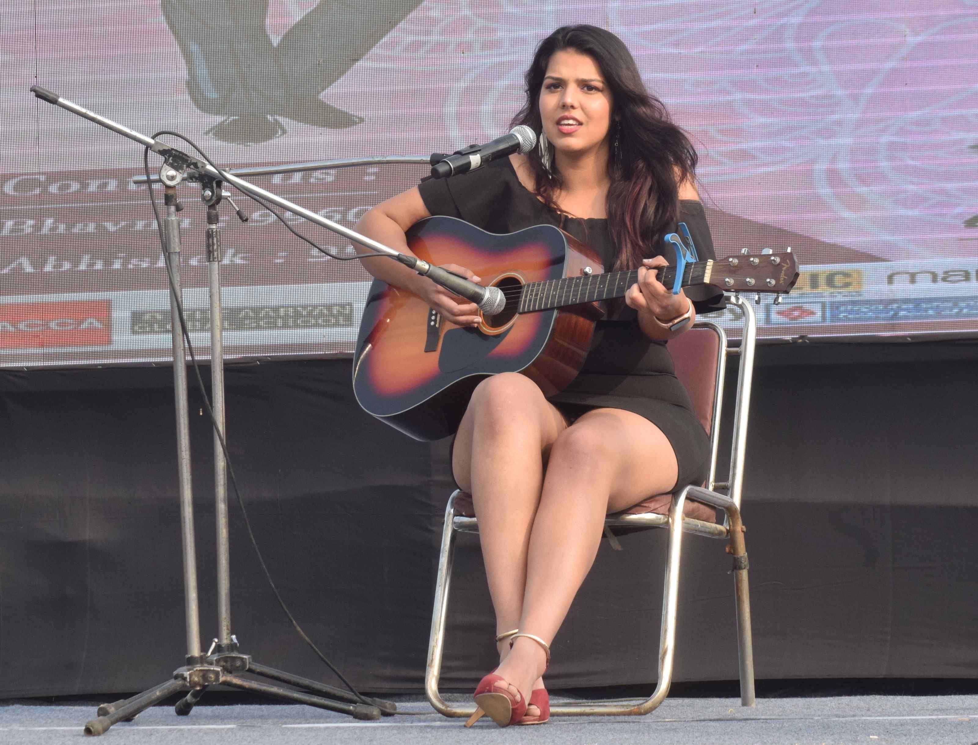 आईआईएम में  इनफ्यूजन 2020 में स्टेज पर गिटार पर गाना सुनाती प्रतिभागी छात्रा।