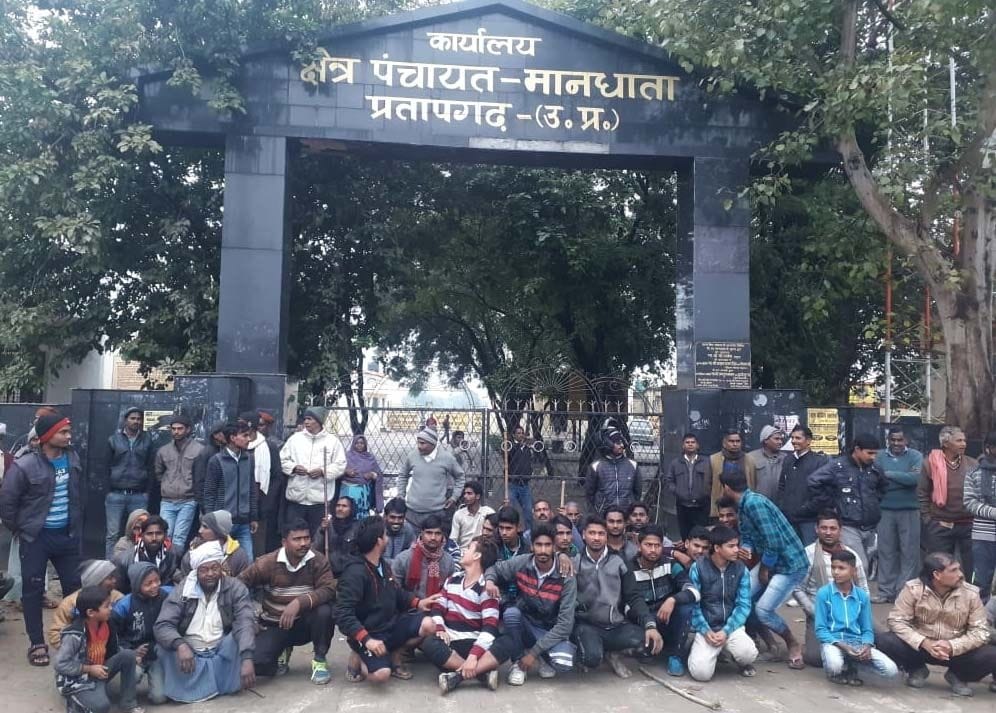 मानधाता ब्लाक परिसर में मवेशियों को बंद कर गेट पर बैठे ग्रामीण।