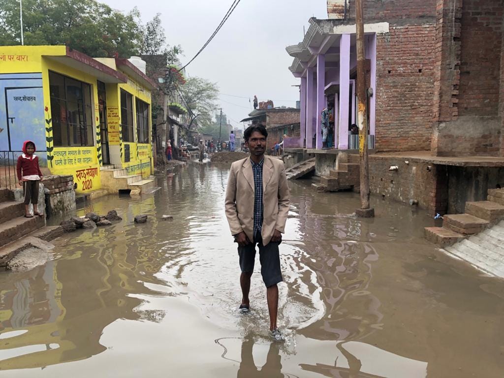 कालपी में नई बस्ती में जलभराव के बीच निकलता युवक कालपी में नई बस्ती में जलभराव के बीच निकलता युवक