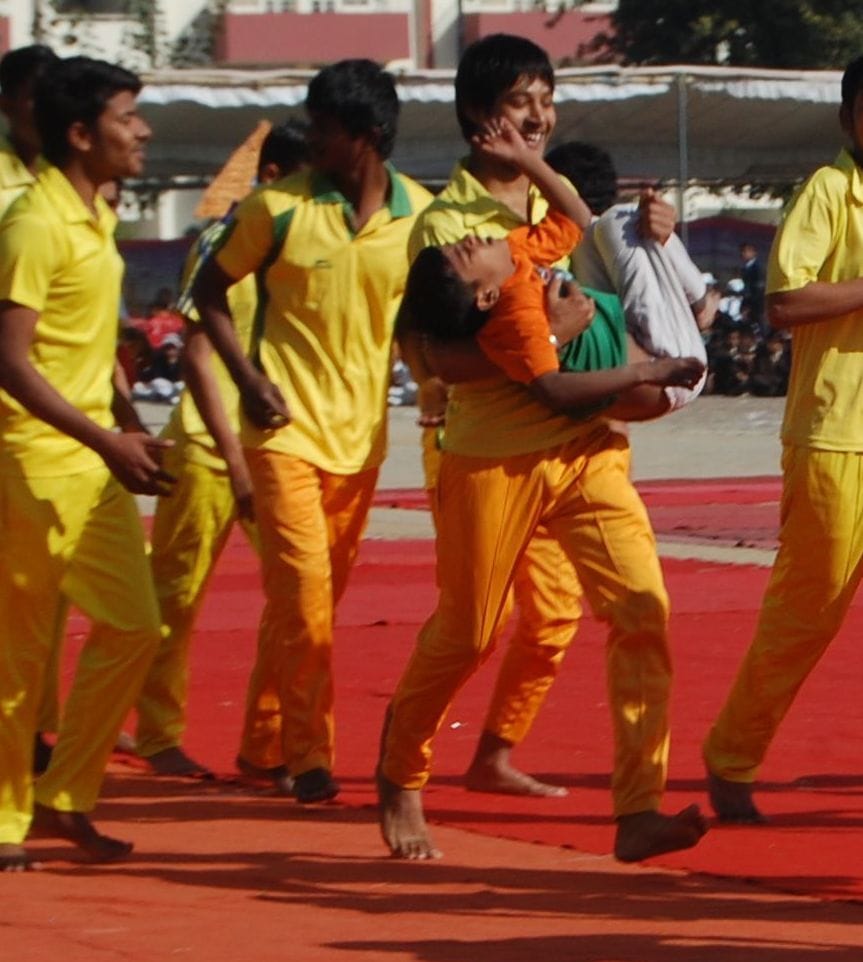 पिरामिड के ऊपर से गिरने वाले छात्र को उठाकर ले जाते साथी छात्र पिरामिड के ऊपर से गिरने वाले छात्र को उठाकर ले जाते साथी छात्र
