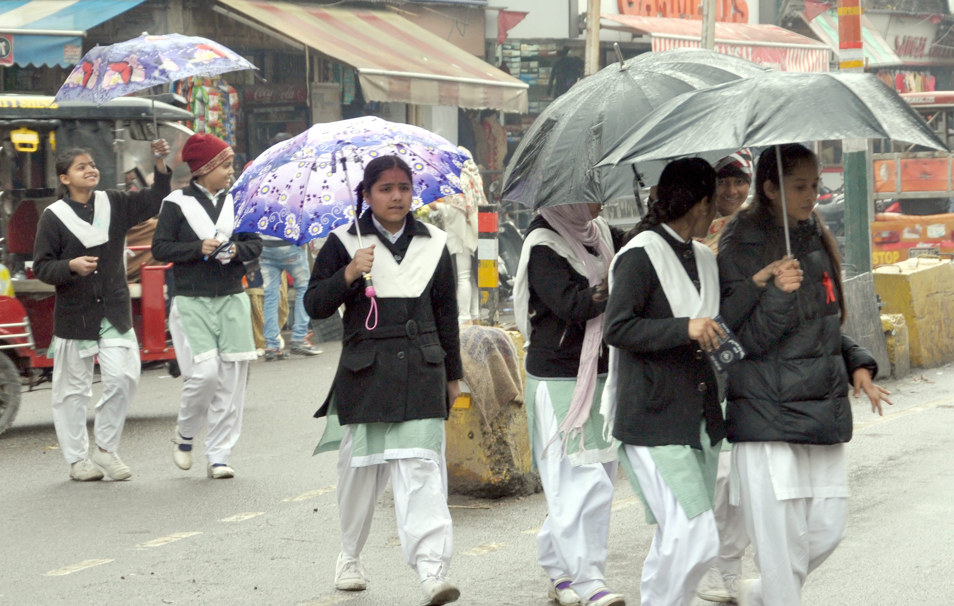 शामली बुंदा बांदी में छाता लगा कर गुजरती छात्राएं शामली बुंदा बांदी में छाता लगा कर गुजरती छात्राएं