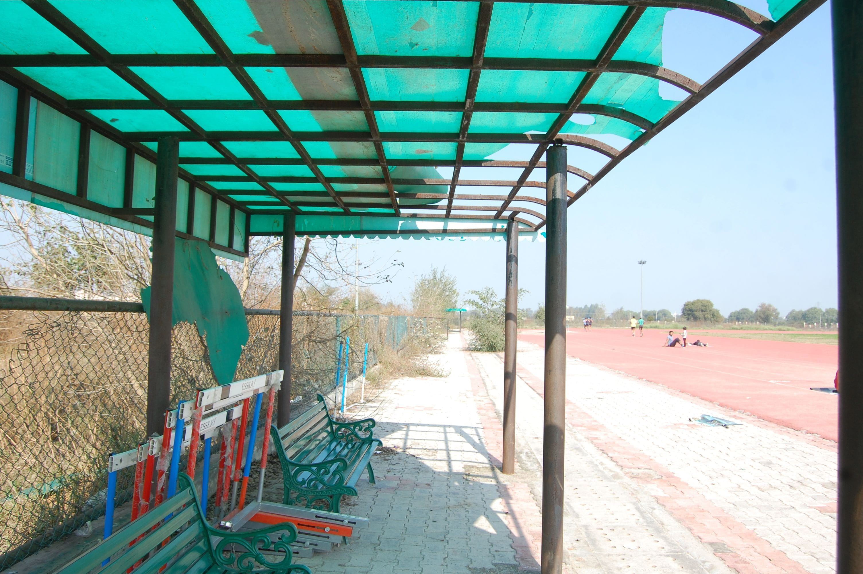 खेल स्टेडियम में बैठने के लिए लगाई गई बैंच के ऊपर से टूटा पड़ा शेड