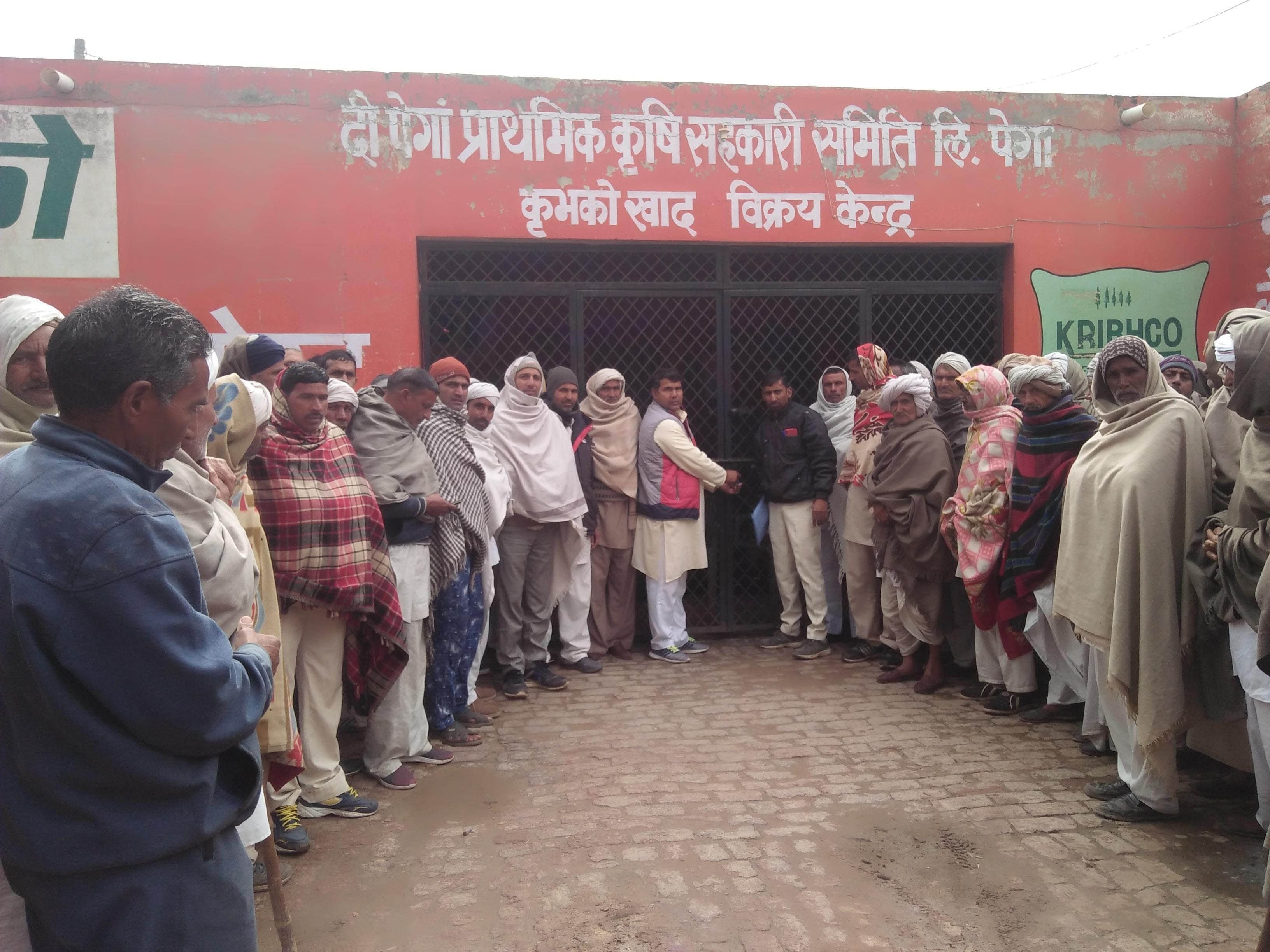  पेगां पैक्स पर ताला लगाते किसान।