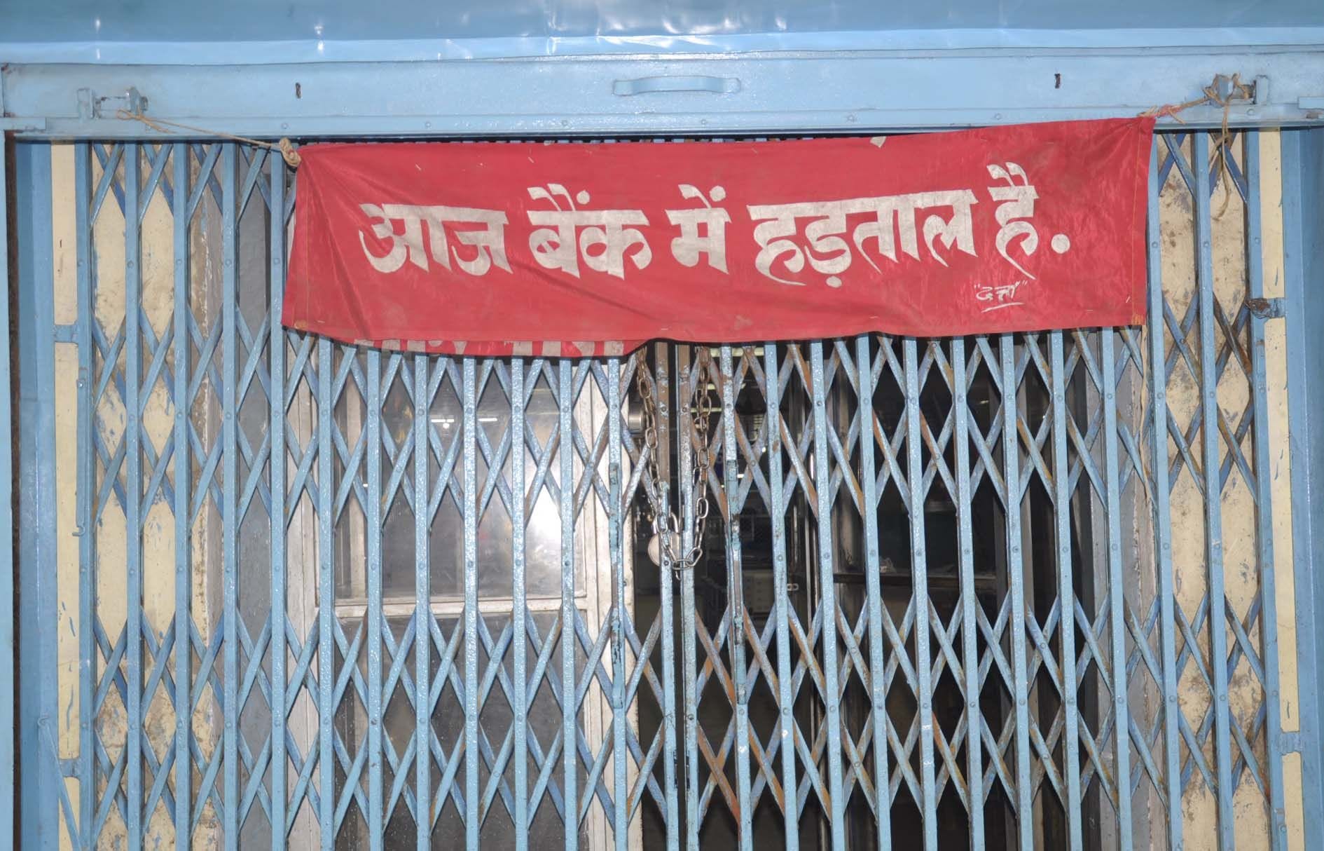 महिला अस्पताल के सामने एसबीआई में कर्मचारियों के हड़ताल पर जाने से बंद बैंक का गेट।