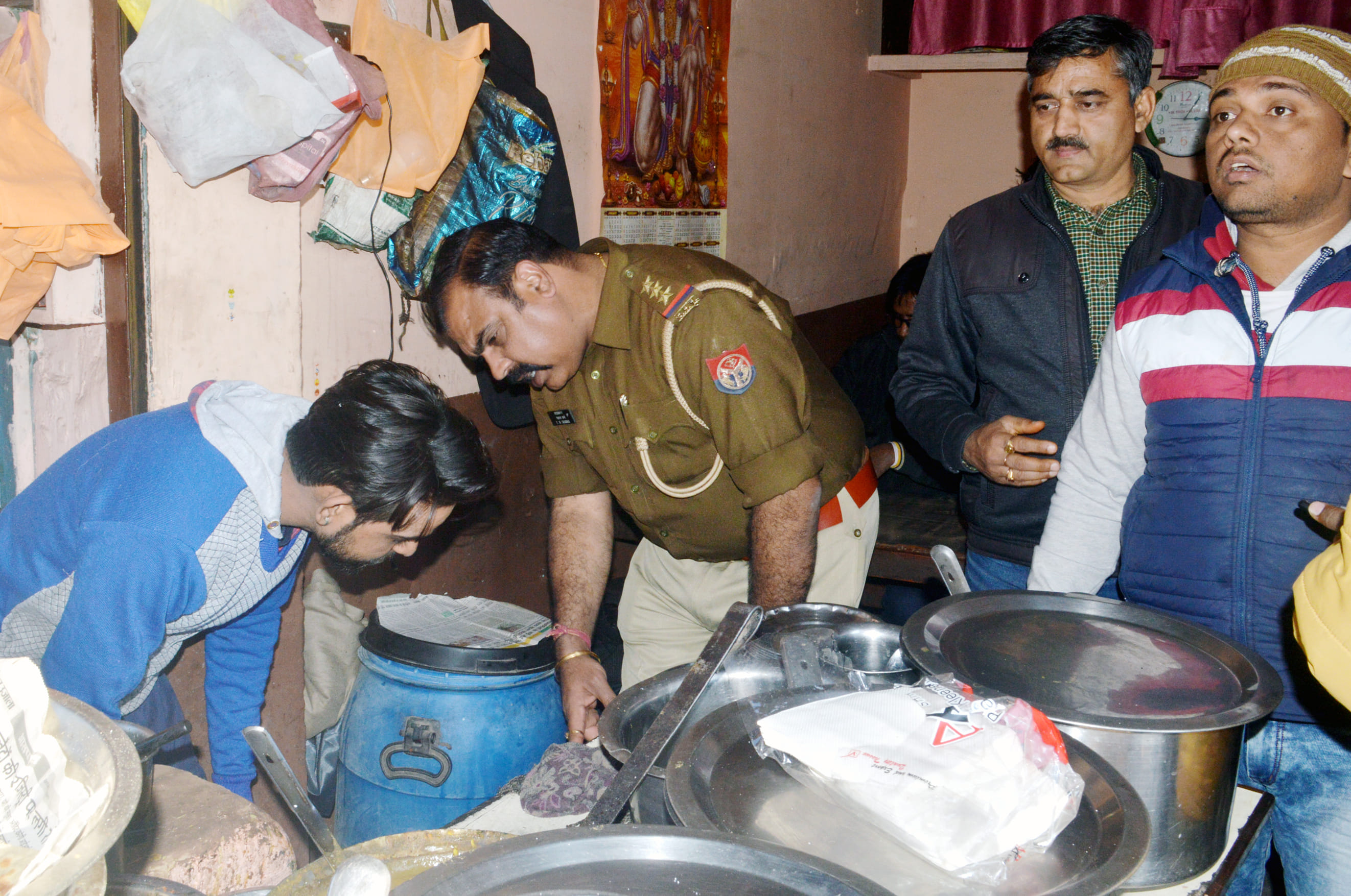 छापामारी दौरान एक ढाबे में पका हुआ भोजन चेक करती टीम।