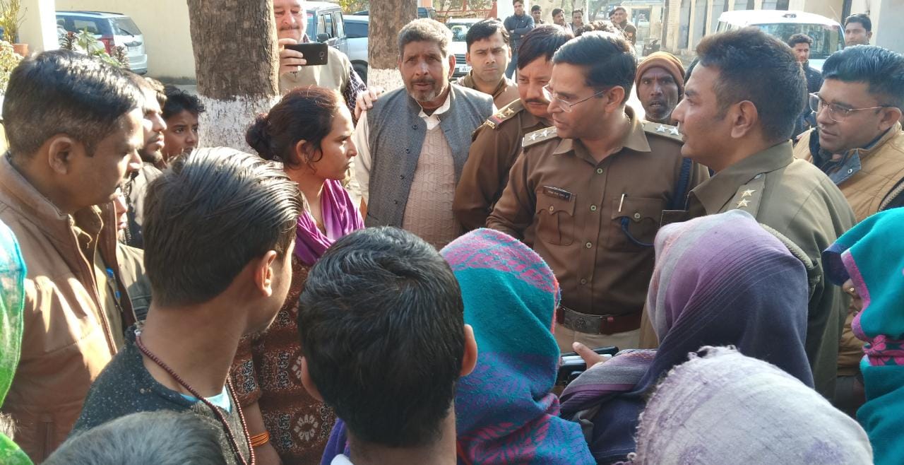 थाने पर हंगामा करते ग्रामीणों को समझाते पुलिस अधिकारी