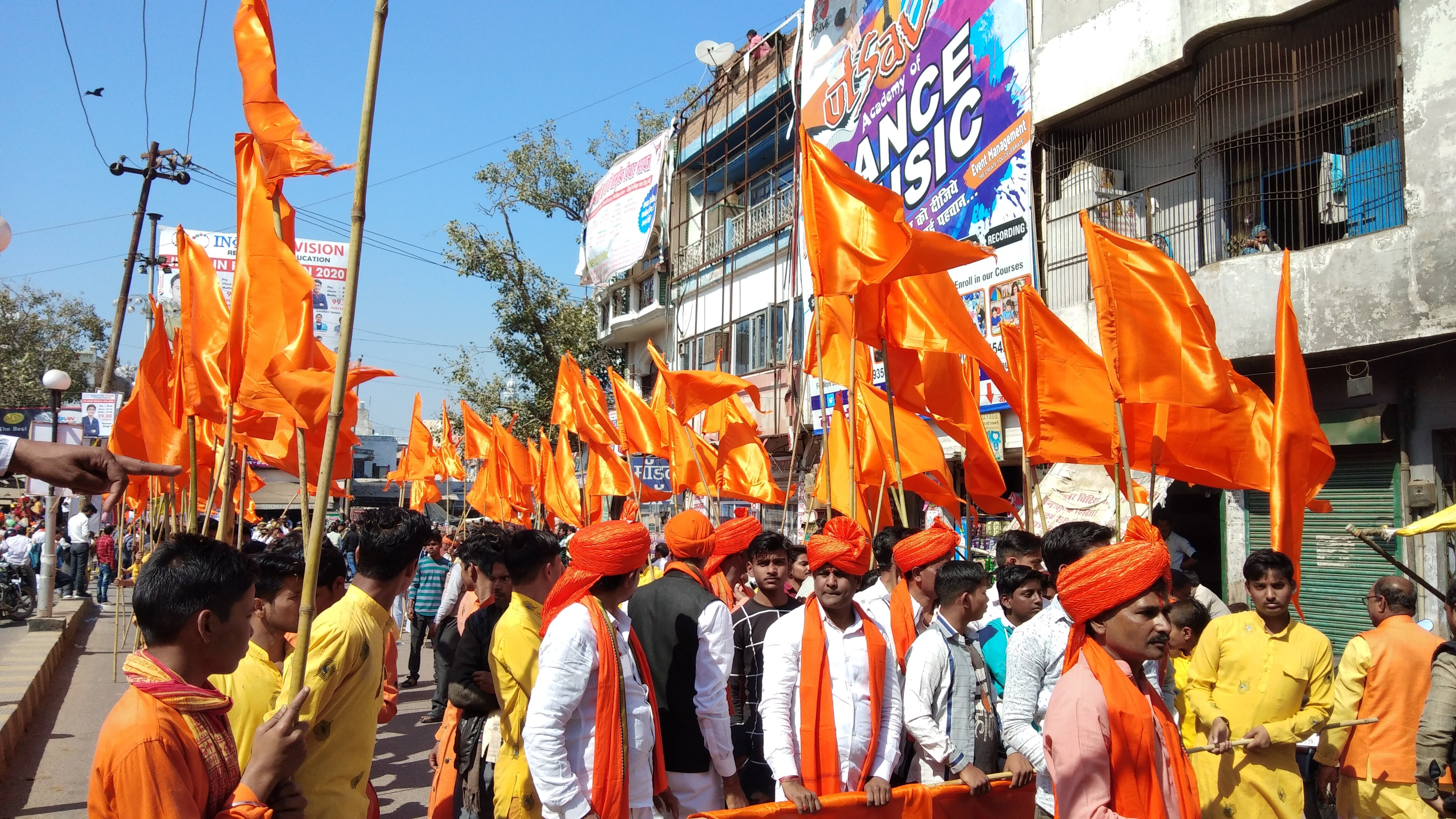 शोभायात्रा में भगवा झंडे लेकर चलते लोग। शोभायात्रा में भगवा झंडे लेकर चलते लोग।