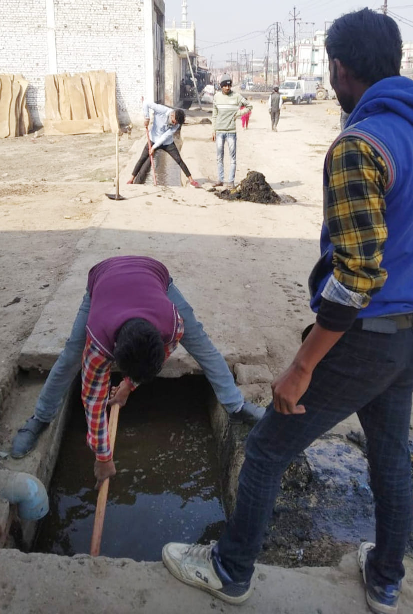 कमेला कॉलोनी में सफाई करते निगम कर्मी