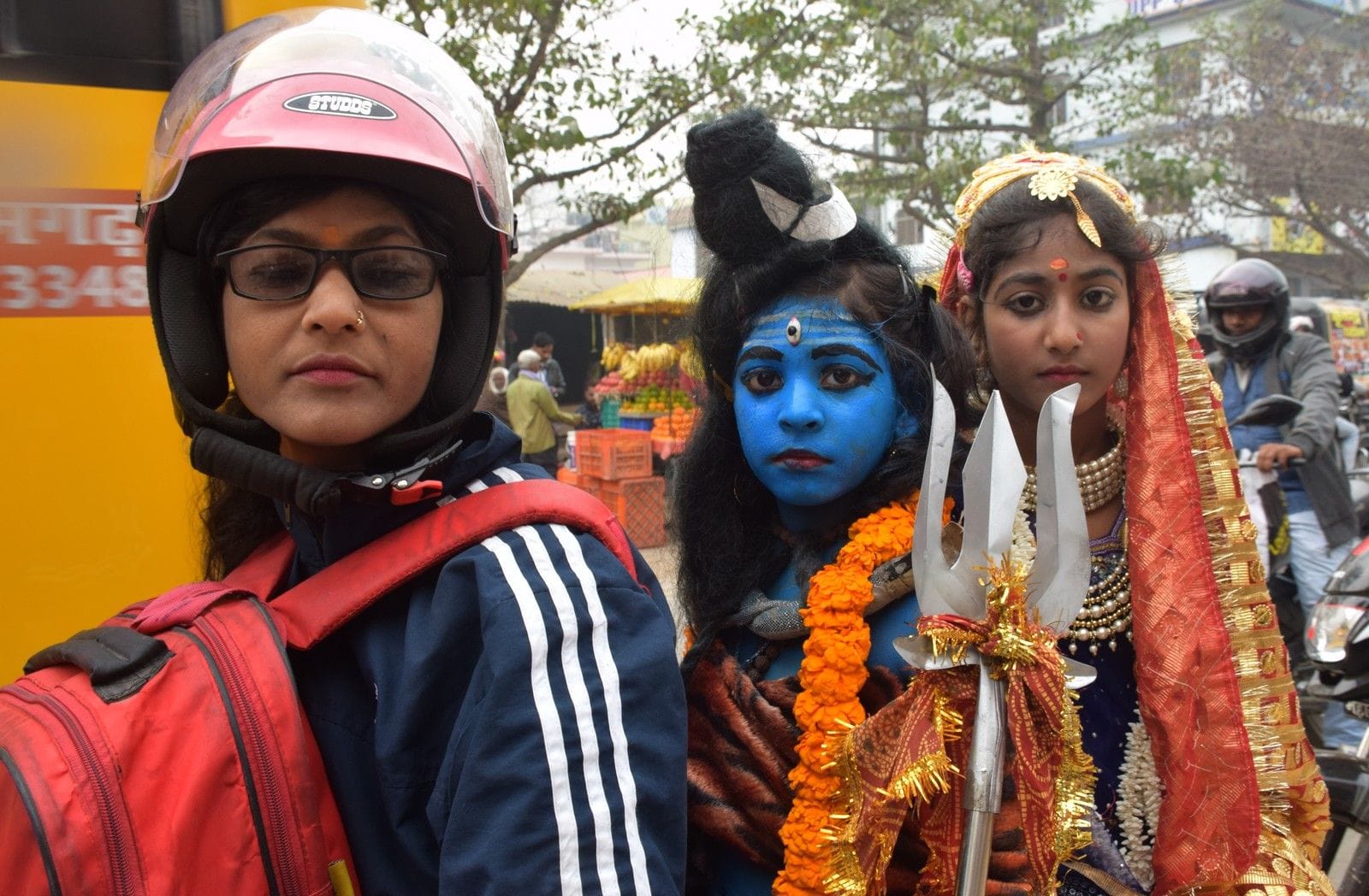 शहर में महाशिवरात्रि पर अपने बच्चों को शिव-पार्वती के वेश में मंदिर ले जाती श्रद्धालु।