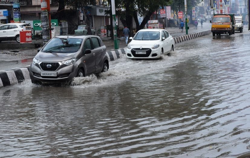 रुद्रपुर के अग्रसेन चौक पर जलभराव से गुजरते वाहन।