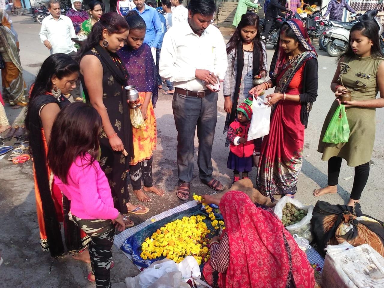 मंदिर के बाहर पूजन सामग्री खरीदती महिलाएं मंदिर के बाहर पूजन सामग्री खरीदती महिलाएं