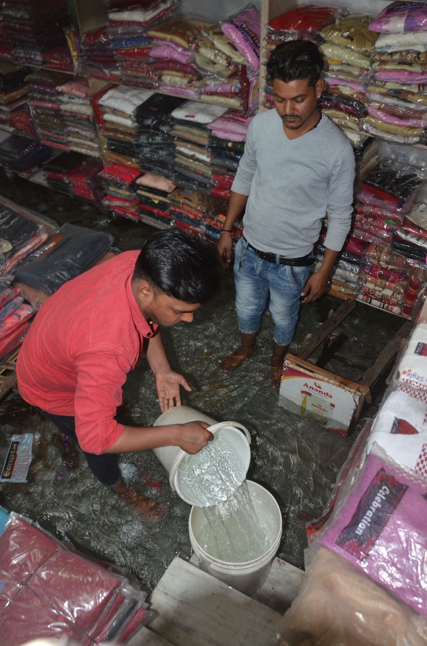 रेलवे स्टेशन के पास दुकान में से पानी निकालते व्यापारी । रेलवे स्टेशन के पास दुकान में से पानी निकालते व्यापारी ।
