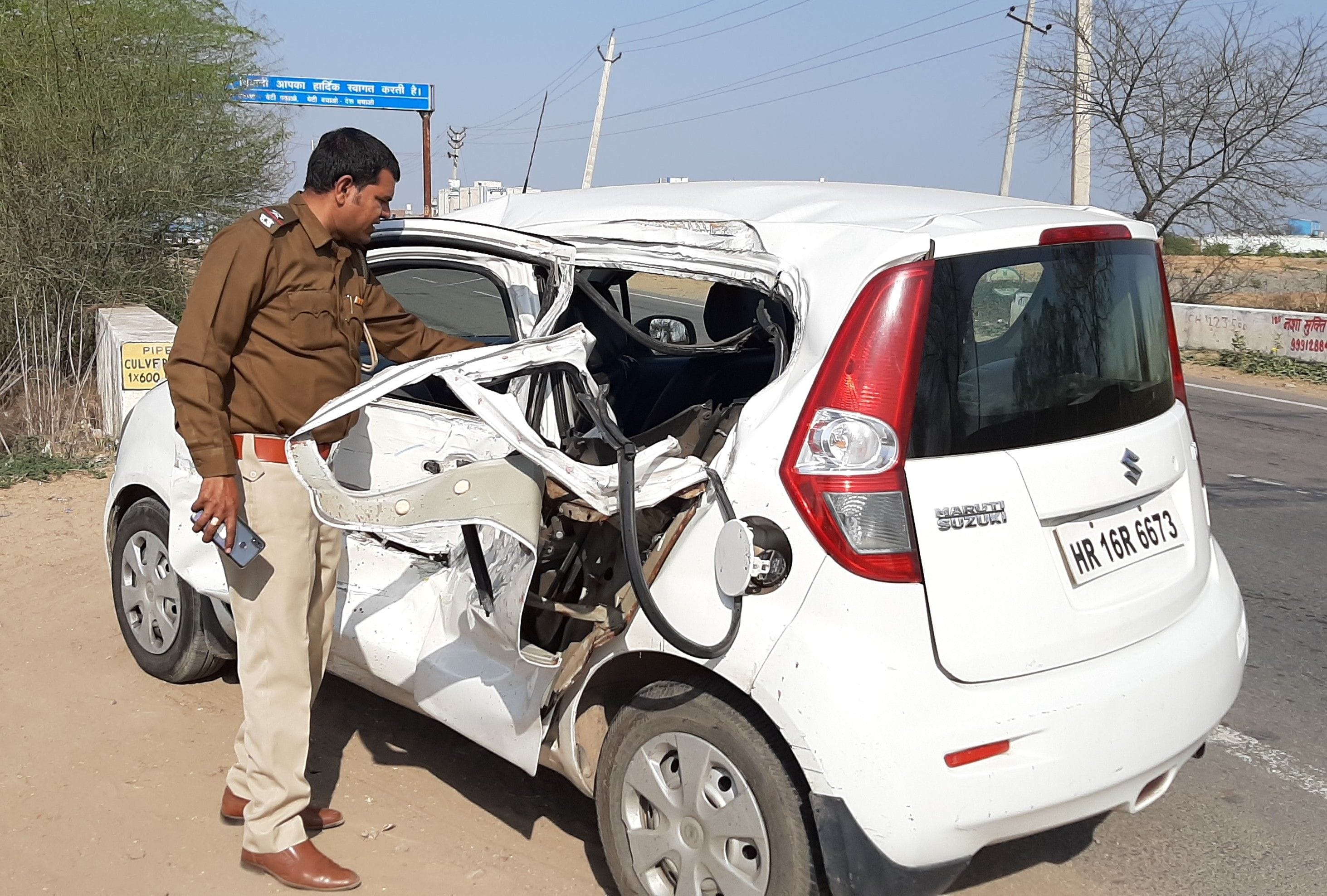 लोहारू रोड पर हुए सड़क हादसे में क्षतिग्रस्त हुई कार व मौके पर जांच करते हुए पुलिस। संवाद न्यूज ए?