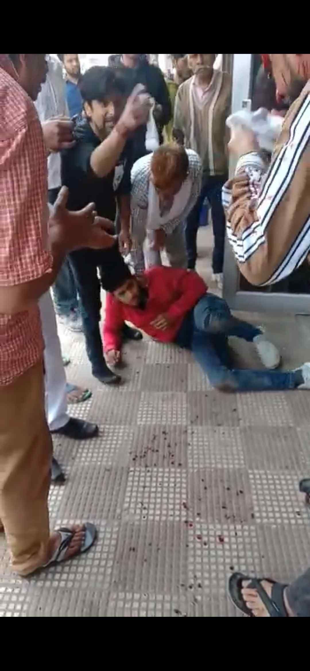लूट के आरोपी को पकड़े हुए दुकानदार। 