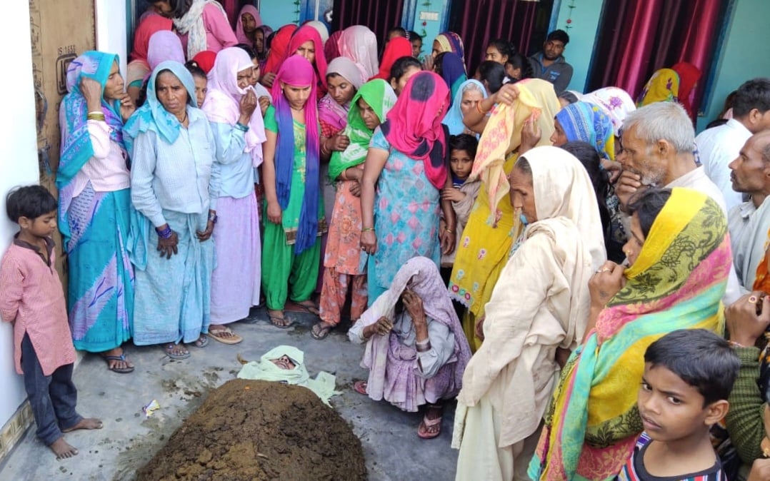 गांव अहरौला तेजवन में सतवीर के मृत शरीर को गोबर में दबाने के बाद गमजदा परिजन।