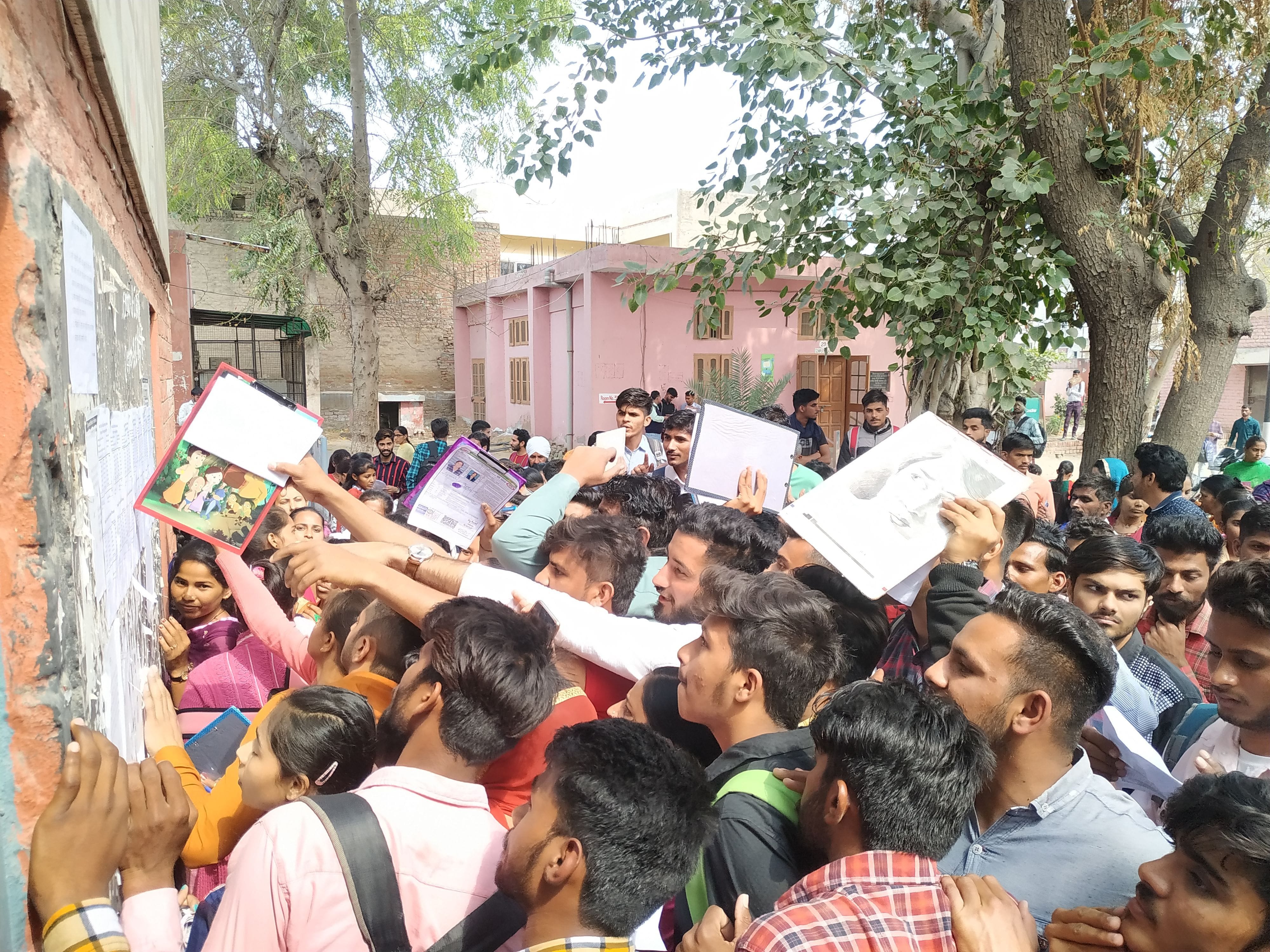 रोलनंबर सूची में अपना रोल नंबर देखते बच्चे।