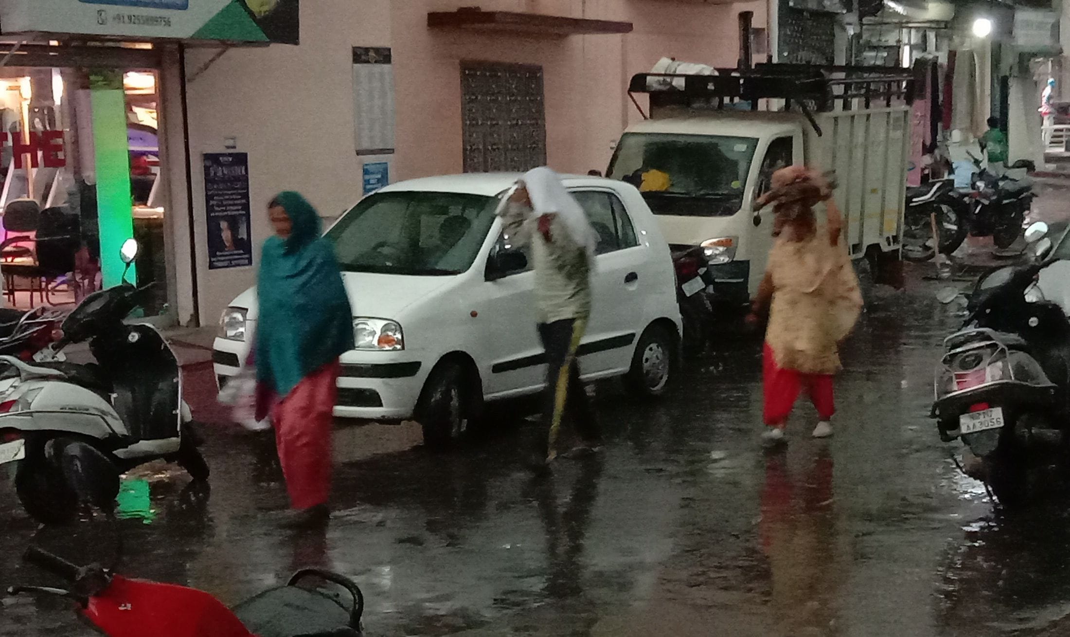 सोनीपत में बारिश के बीच भगीते हुए जाती महिलाएं। सोनीपत में बारिश के बीच भगीते हुए जाती महिलाएं।