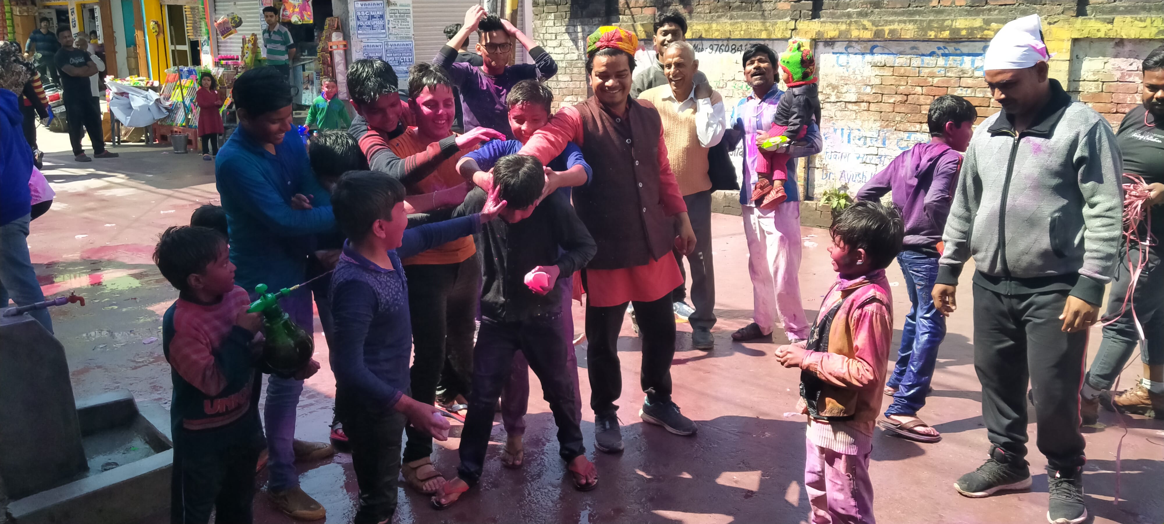 धामपुर में मेन बाजार में एक दूसरे को रंग से सराबोर करते युवक। धामपुर में मेन बाजार में एक दूसरे को रंग से सराबोर करते युवक।