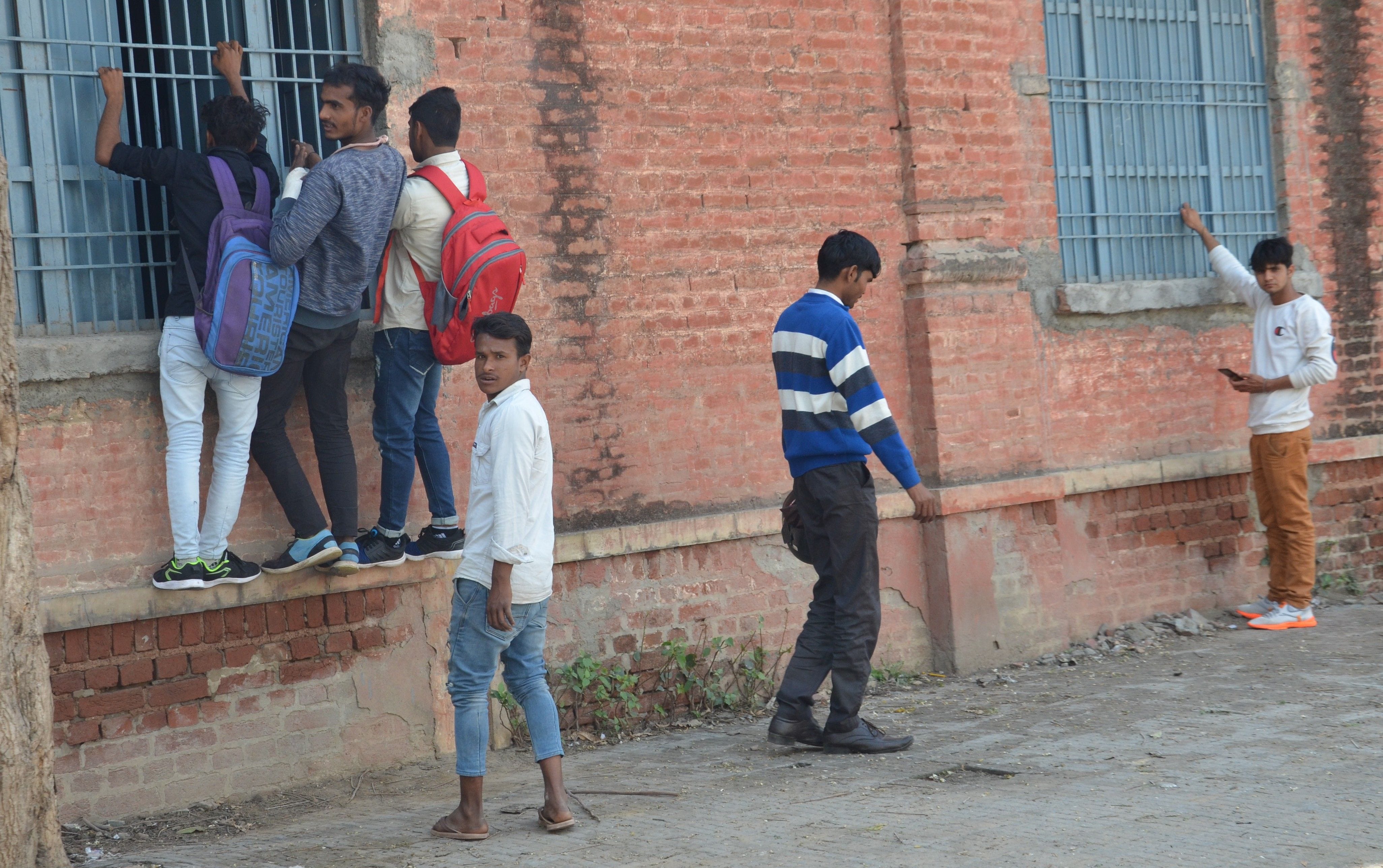 गवर्नमेंट सीनियर सेकेंडर स्कूल में बोर्ड परीक्षा के दौरान नकल कराने के लिए खिड़कियों पर लटके यु?