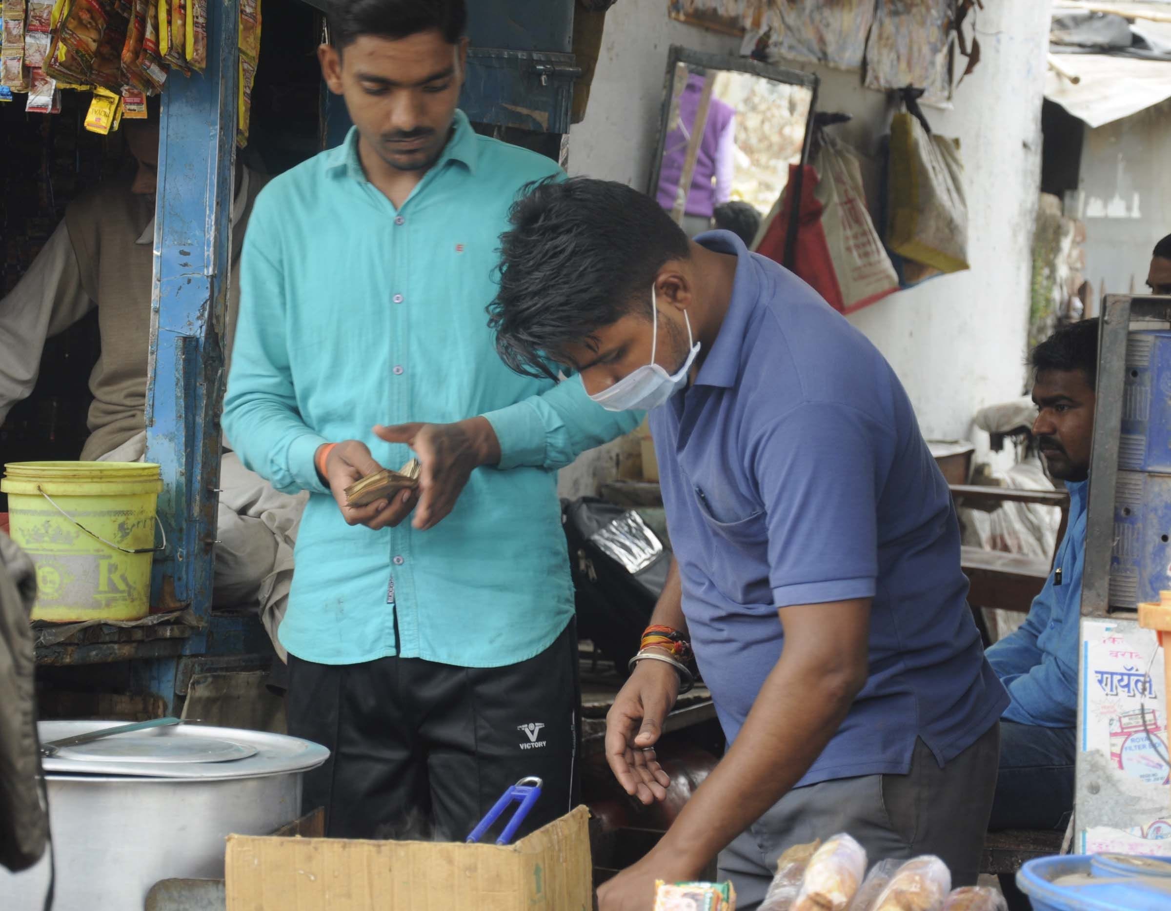 जिला अस्पताल के सामने कोरोना से बचाव को मास्क लगाये दुकानदार।