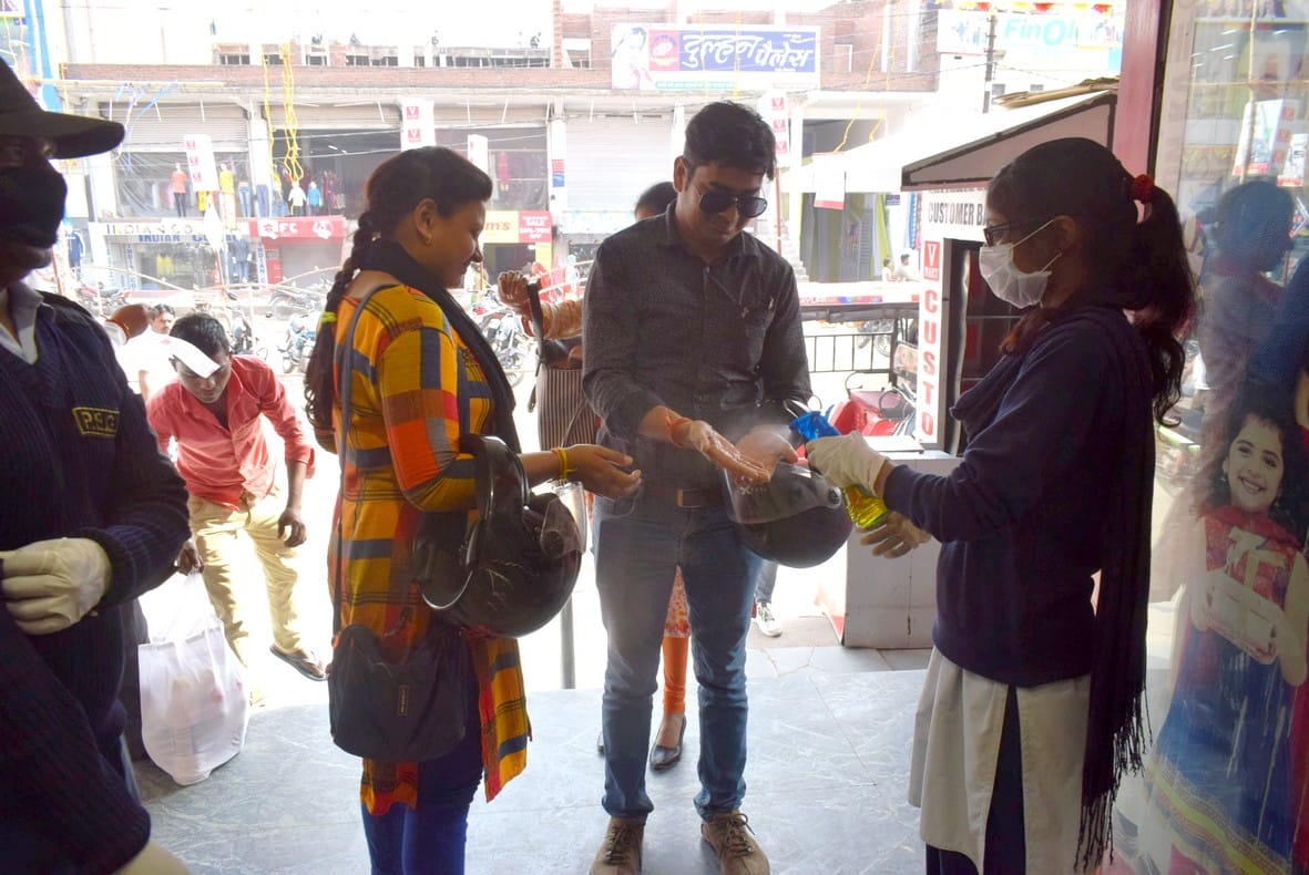 07- बदलापुर पड़ाव स्थित वी मार्ट शापिंग मॉल में आने वाले ग्राहकों को सेनेटाइज स्प्रे करवाती कर्मच?