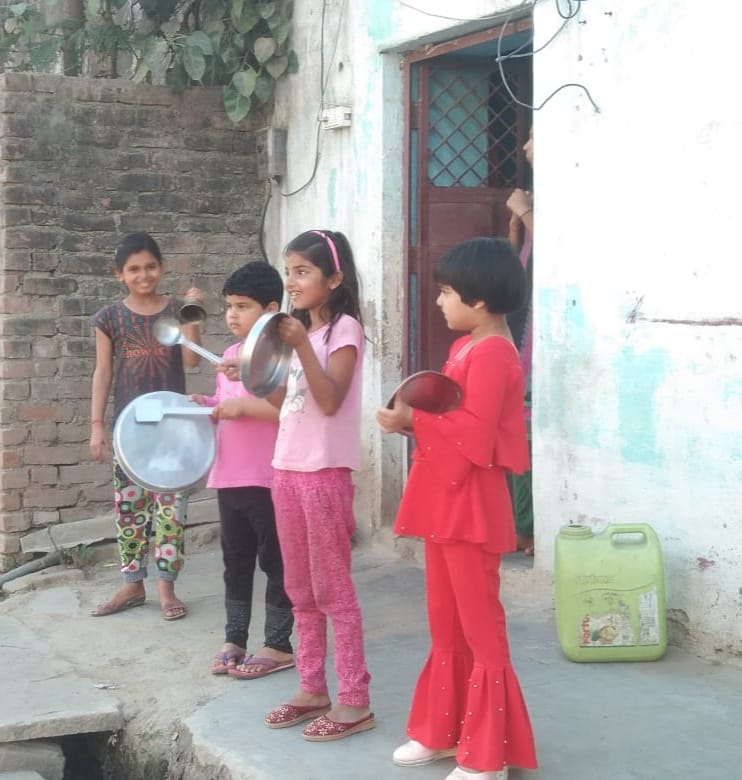 नई बस्ती में थाली बजाते बच्चे