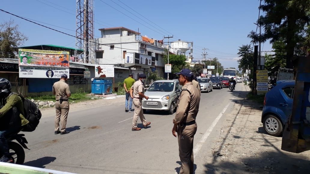 हाईवे पर वाहनों की चेकिंग कर उन्हें निर्देश देते पुलिस कर्मी।
