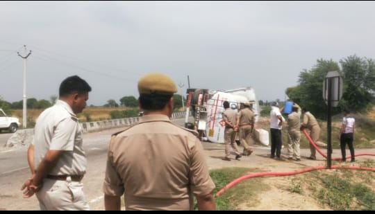 पलट पड़े टैंकर पर पानी डालते फायर बिग्रेड के कर्मचारी पलट पड़े टैंकर पर पानी डालते फायर बिग्रेड के कर्मचारी