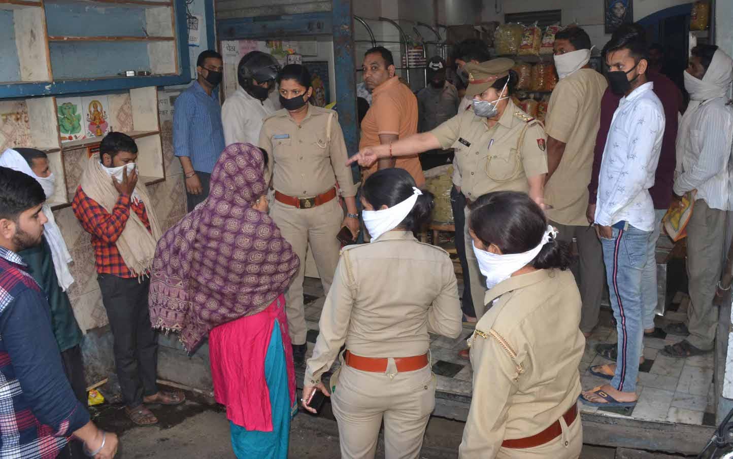 शामली परचून की दुकान में समान ले रहे लोगो को समझाती महिला पुलिस कर्मी