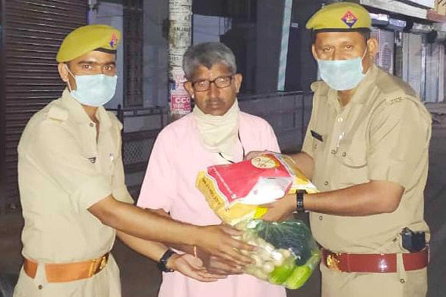 राठ के गुलाबनगर में जरूरतमंदों को राशन देते पुलिसकर्मी