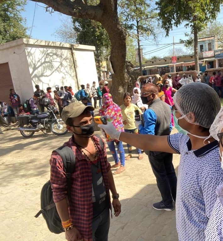 लाकडाउन में फंसे लोगों के बस से सैदपुर में पहुंचने पर स्क्रीनिंग करते चिकित्सक।