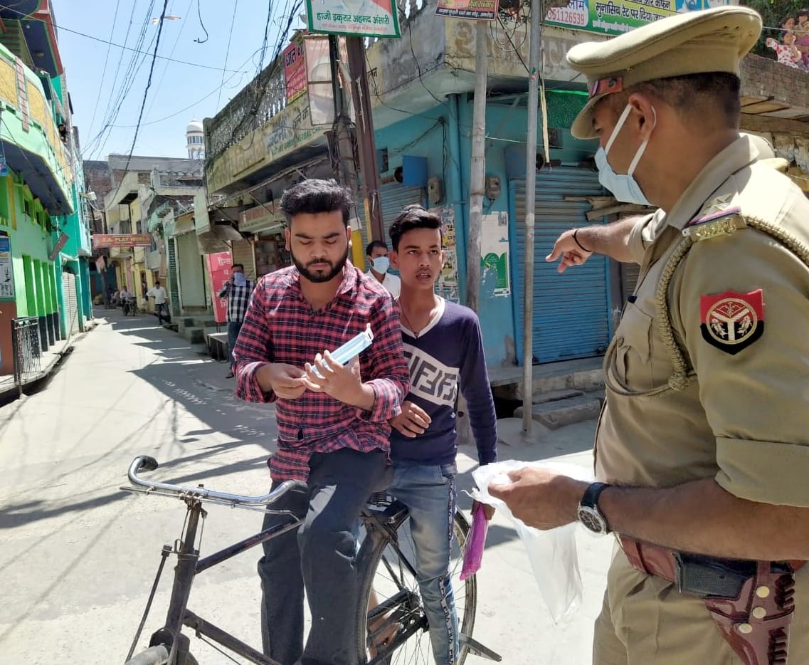अमरोहा लॉक डाउन में घुमते साइकिल सवार युवकों को फटकार लगाता दरोगा।