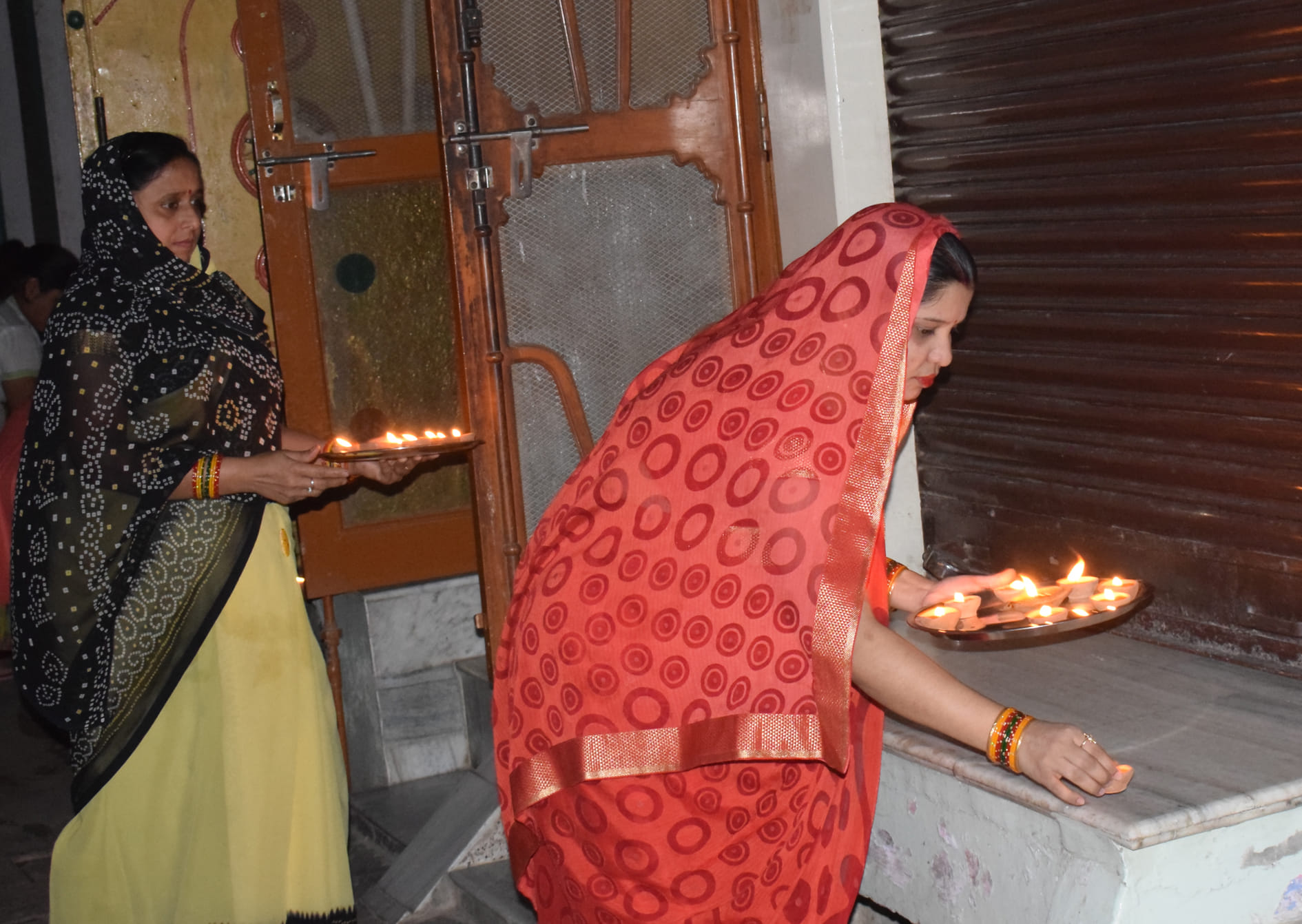 कासगंज में अपने घर के बाहर दीपक जलाती महिलांए । कासगंज में अपने घर के बाहर दीपक जलाती महिलांए ।