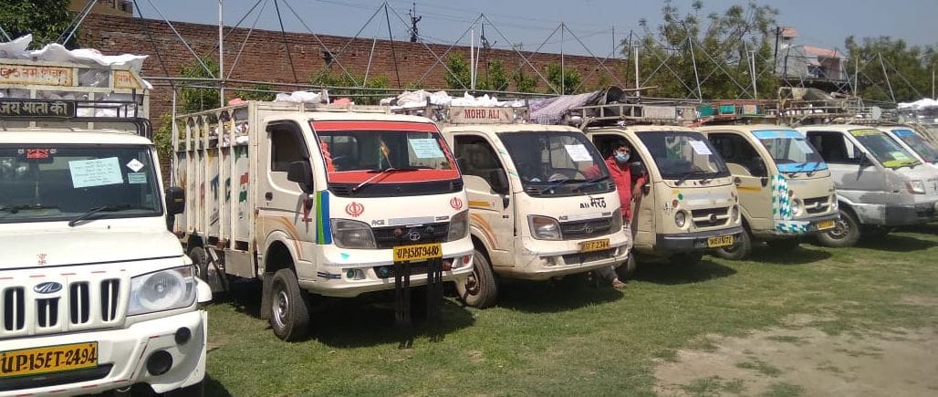 मैदान में खाद्य सामग्री से लदे खड़े वाहन।