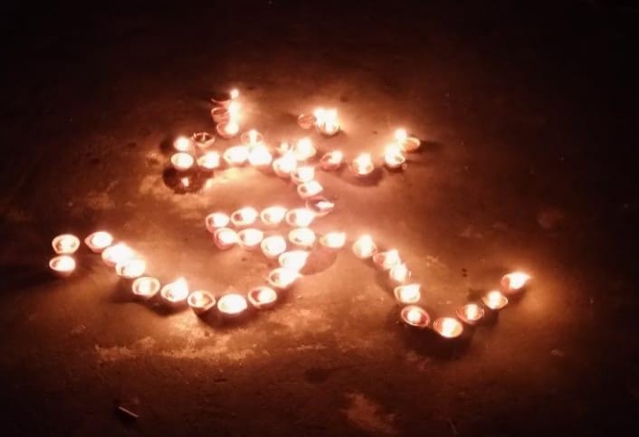 दीप उत्सव में ओइम की आकृति में जलाए गए दीपक।